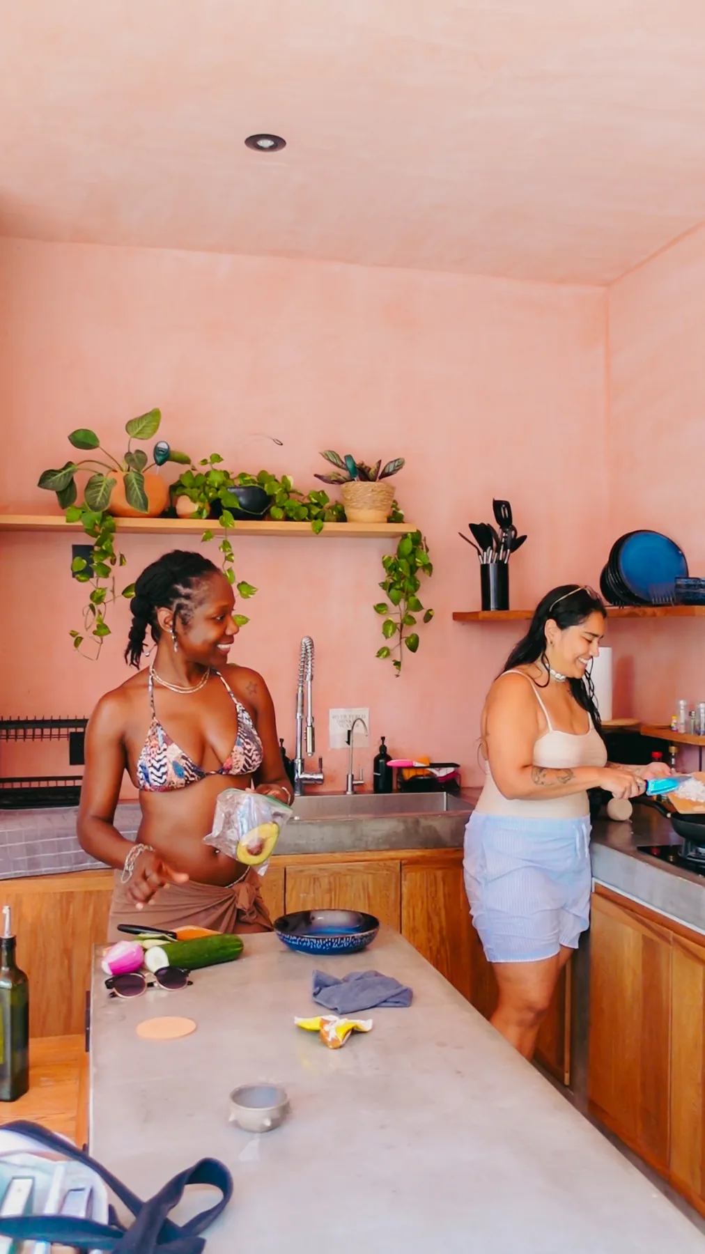 Two guests preparing lunch together at the counter of the open-air kitchen at Amplitude Coliving, La Punta